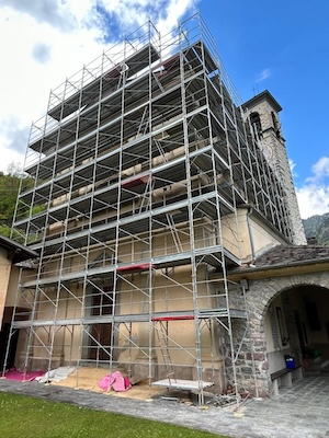 Cantiere di restauro della chiesa parrocchiale di Mezzoldo con ponteggi sulle facciate
